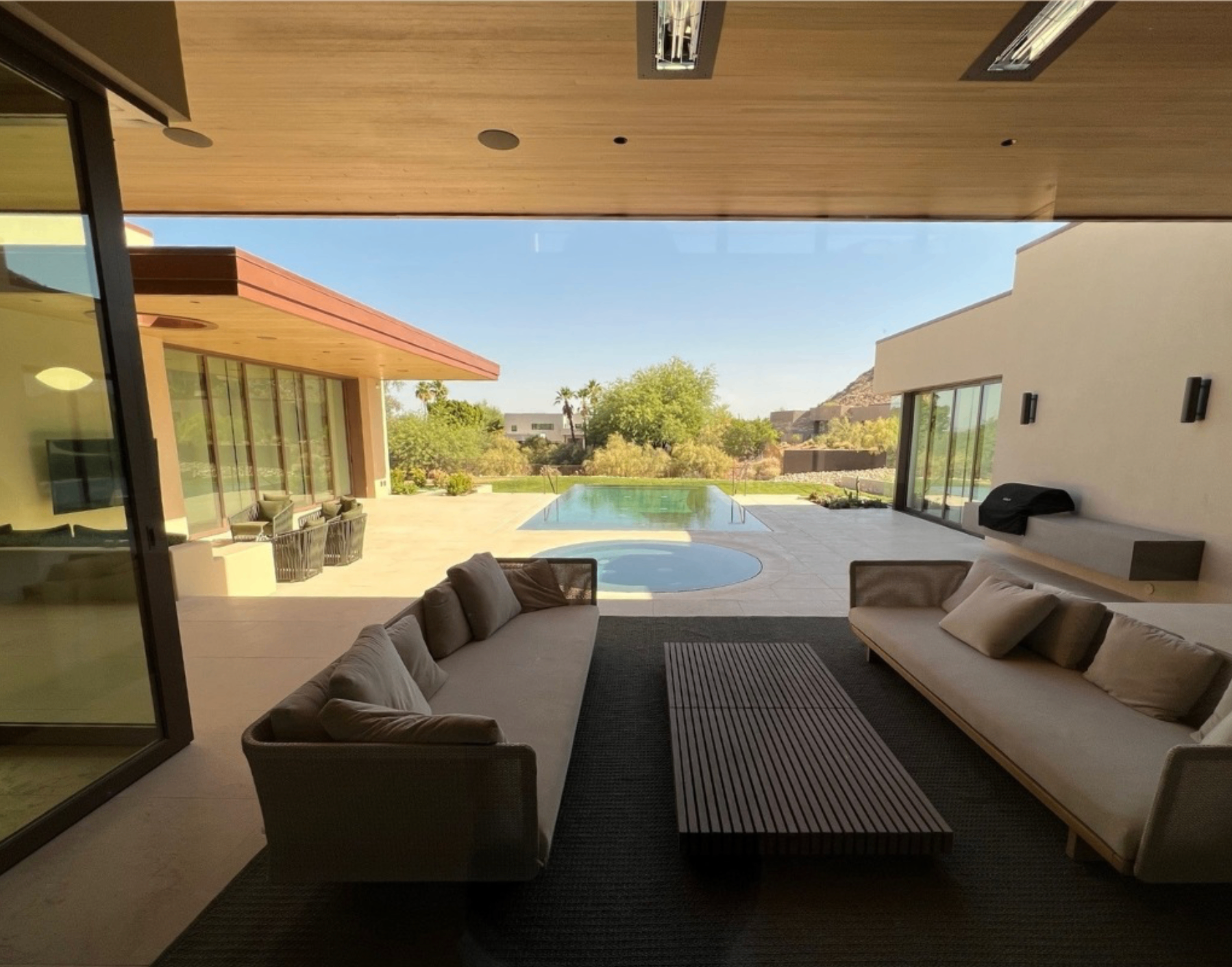 Covered outdoor lounge overlooking a private pool and grounds.