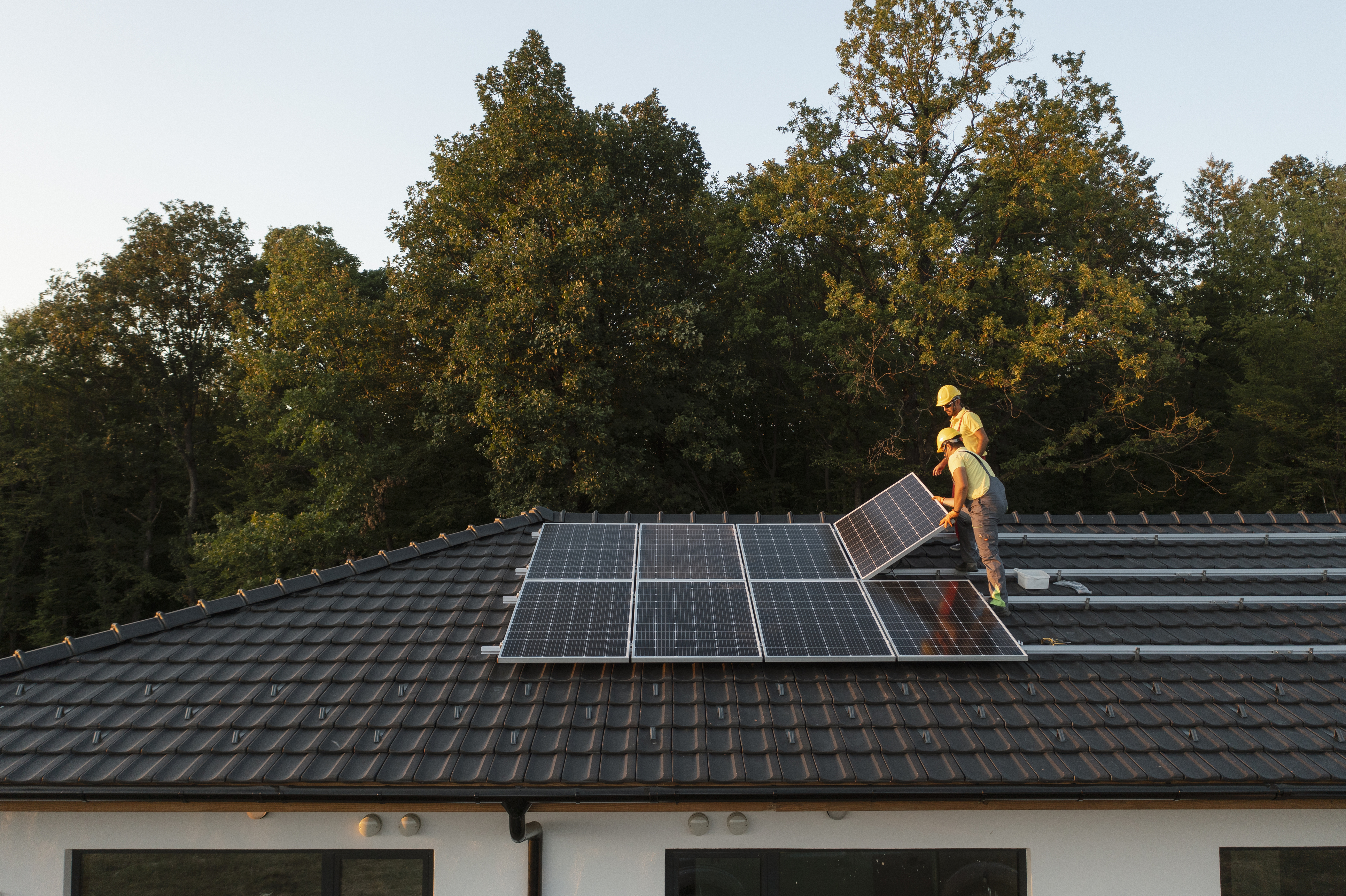 Crew installing solar panels on an estate roof.
